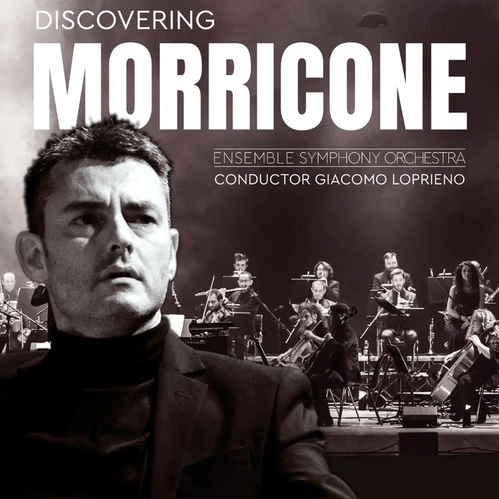 © Discovering Morricone / Anna Barbacovi Ein Dirigent steht mit ausgestrecktem Arm vor einem Orchester auf der Bühne, darüber der Titel „Discovering Morricone“.