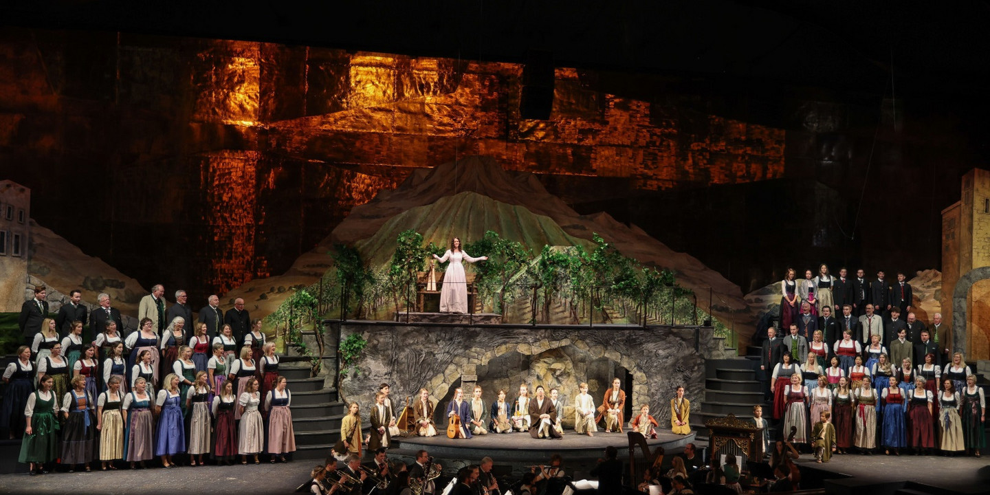 Große Bühnenproduktion des Salzburger Adventsingens mit Chor, Orchester und Solisten vor einer festlichen Bergkulisse.