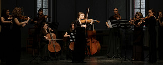 Streichensemble mit Solistin bei Konzert auf Bühne im Saal