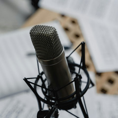 Studio-Mikrofon vor verstreuten Notenblättern