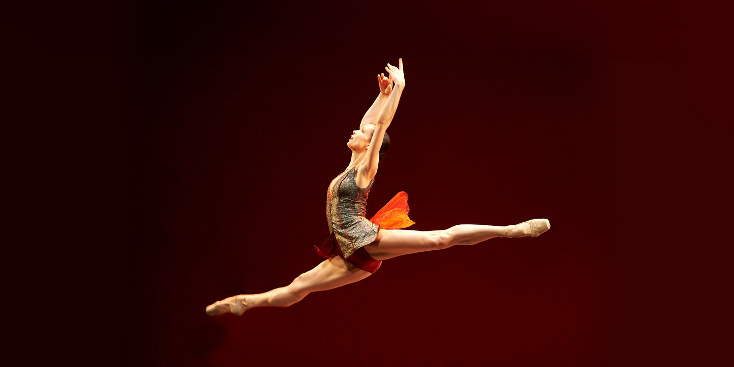 Tsymbal, Sommer Theater Park © Michael Poehn Ballerina in hohem Spagatsprung auf rot beleuchteter Bühne