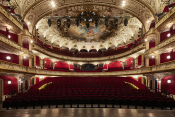 © Emil Blau / Martin Geyer Prunkvoller Theatersaal des Volkstheaters Wien mit rotem Samt, goldenen Verzierungen und bemalter Decke.