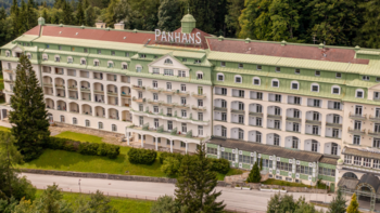 © www.kultursommer-semmering.at Außenansicht des traditionsreichen Grandhotels Panhans am Semmering inmitten von Waldlandschaft.