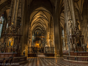 Blick ins prächtige, gotische Innere des Stephansdoms mit hohen Pfeilern, kunstvollen Altären und warm leuchtendem Altarraum im Hintergrund.
