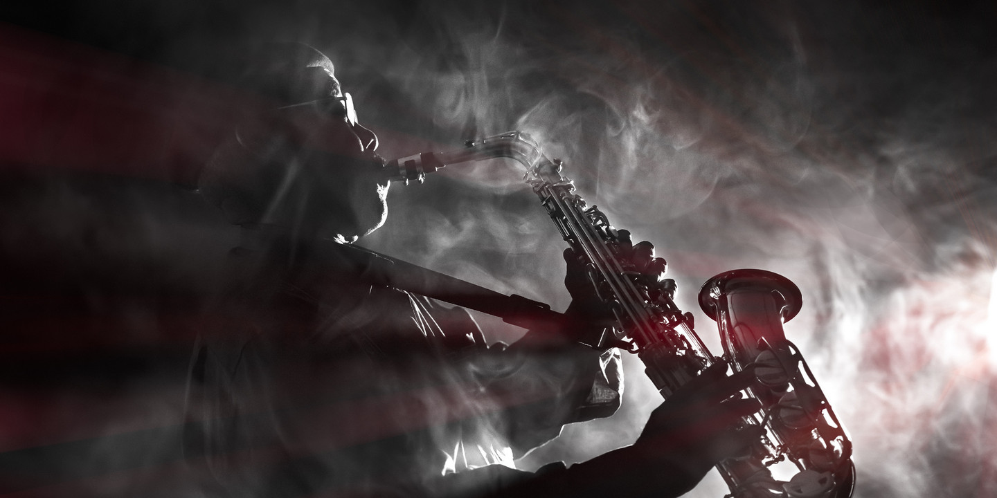 Bild: Adobe Stock Jazzsaxophonist im Gegenlicht mit Nebel und dramatischer Lichtstimmung