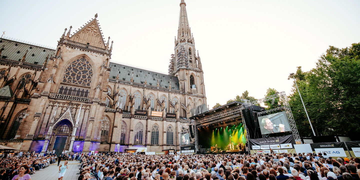 © Julian Quirchmair Großes Open-Air-Konzert vor dem Mariendom in Linz mit Bühne, Publikum und Abendstimmung.