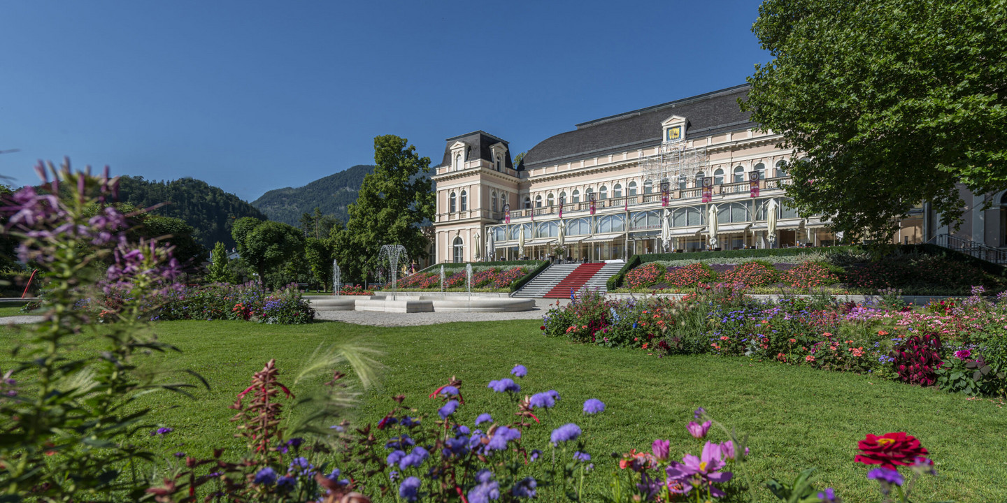 © Wolfgang Stadler Theaterhaus Bad Ischl mit Blumenbeet im Kurpark und Bergen im Hintergrund