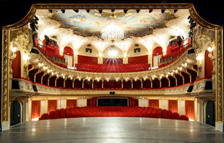 © Neumayr/Christian Leopold Blick von der Bühne in den prachtvollen Zuschauerraum eines Theaters mit rotem Samt, goldenen Verzierungen, Kronleuchter und Deckenmalerei. Die Sitzreihen sind leer, die Architektur wirkt historisch und opulent.