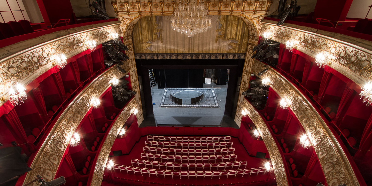 Prunkvoller Zuschauerraum mit Blick auf leere Bühne eines historischen Theaters